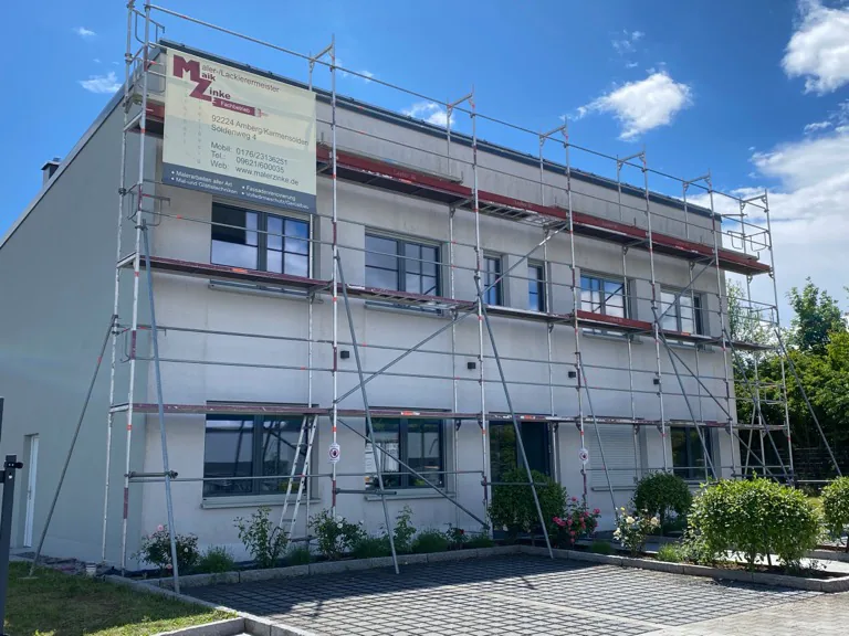Mehrfamilienhaus im Gerüst während der Anbringung eines Wärmedämmverbundsystems